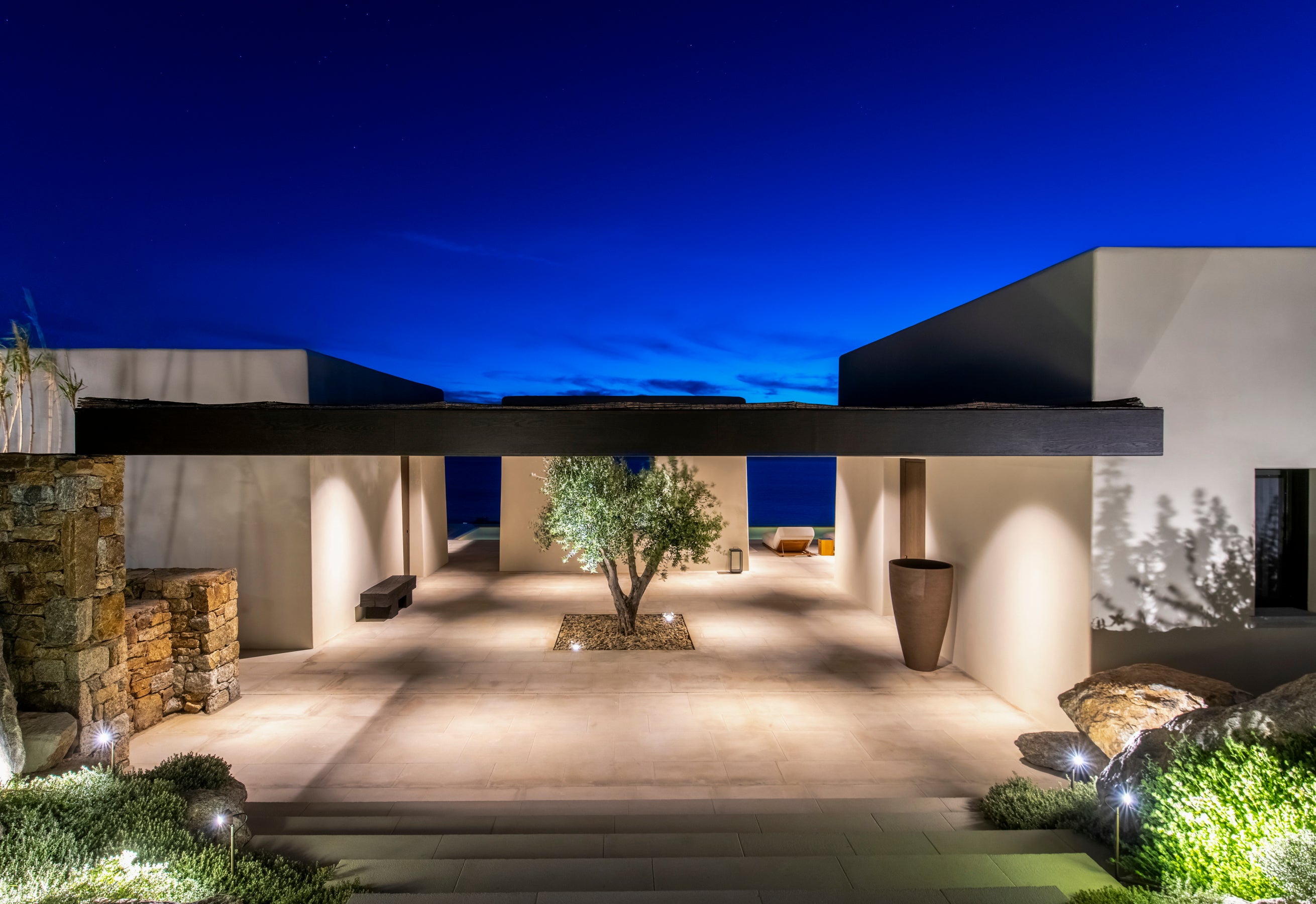 Modern outdoor patio area of a house with decorative elements and lighting.