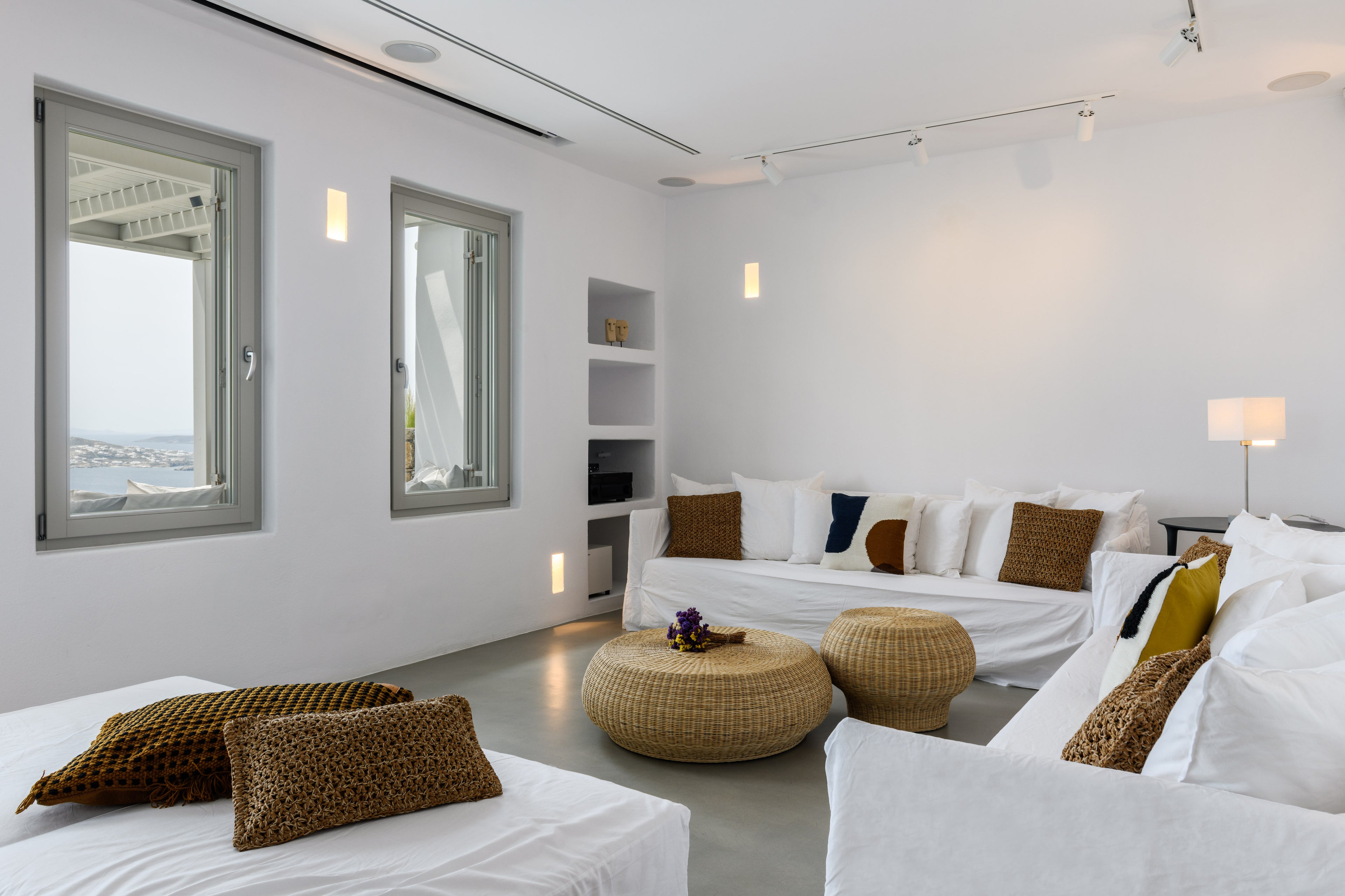 Modern living room with white walls, white sofa, and decorative pillows.