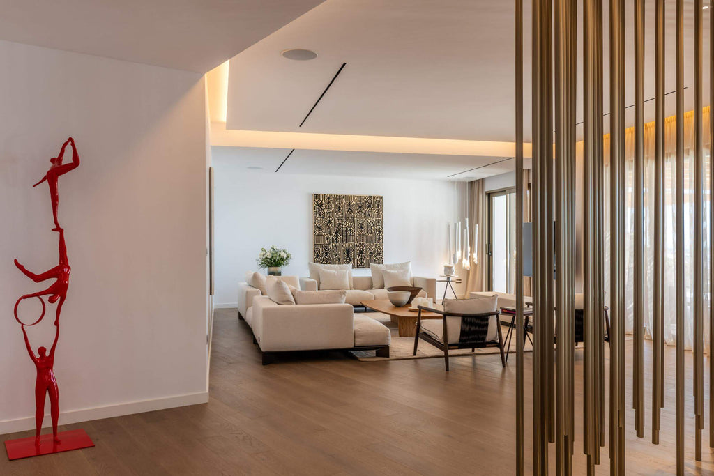 Modern living room with a red sculpture, beige sofas, and wooden floor.