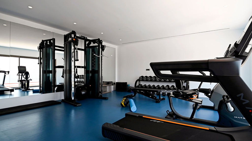 Modern gym interior with treadmills, weight machines, and dumbbells.