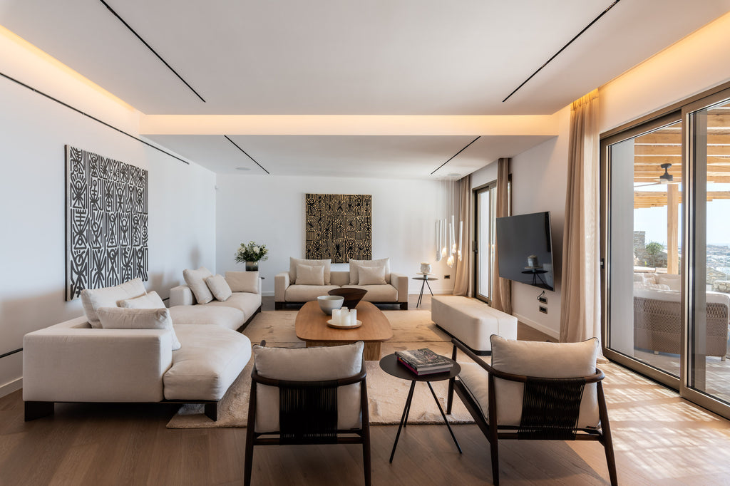 Modern living room with beige sofas, wooden coffee table, and large windows.